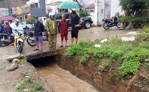 Bé trai đi xe đạp điện ngã xuống cống bị nước cuốn trôi