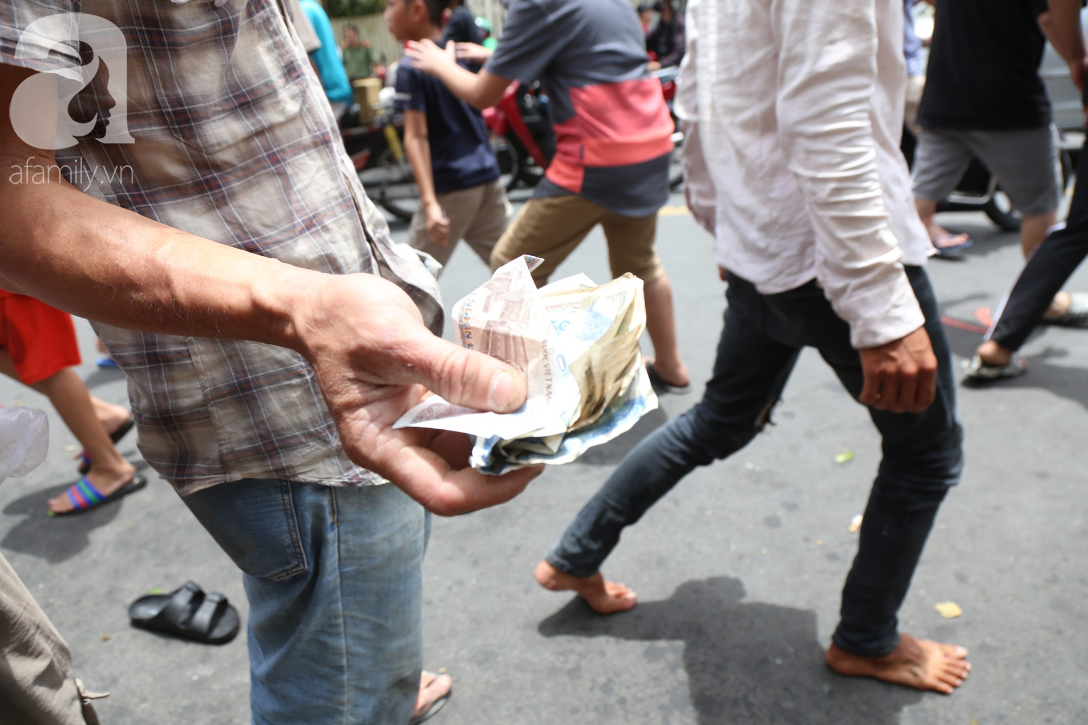 Hàng trăm thanh niên bất chấp nguy hiểm leo tường, chen nhau để giật đồ cúng cô hồn ở Sài Gòn