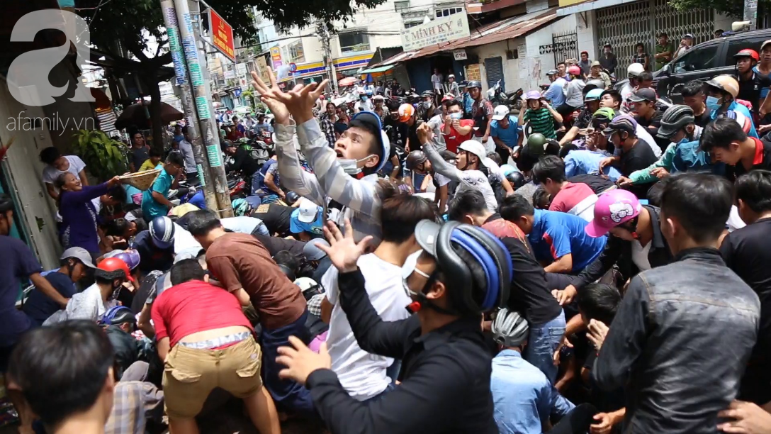 Hàng trăm thanh niên bất chấp nguy hiểm leo tường, chen nhau để giật đồ cúng cô hồn ở Sài Gòn