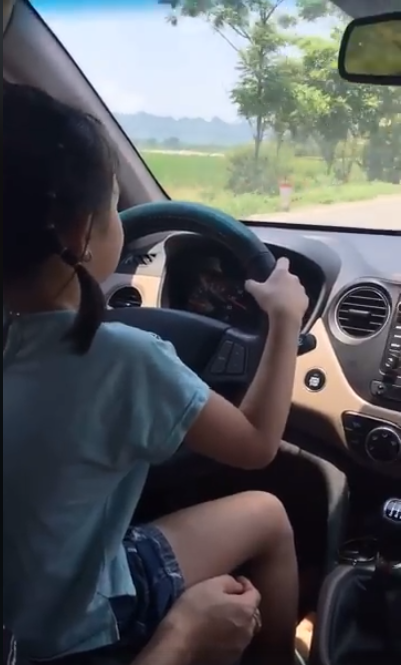 Bố cho con gái nhỏ cầm lái ô tô, mẹ quay phim khen lái xe siêu thế khiến cư dân mạng bức xúc