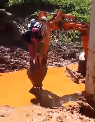 Giáo viên ngồi máy xúc qua điểm sạt lở đến trường