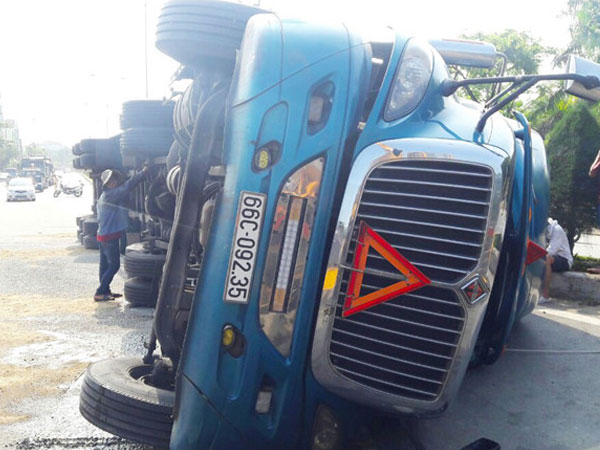 Xe đầu kéo container lật trên quốc lộ 1, hàng trăm lít dầu đổ ra đường