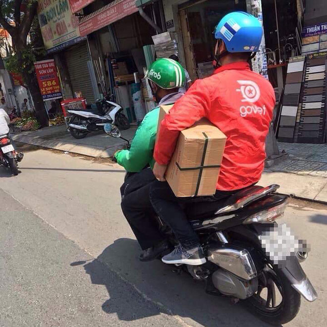 Thanh niên áo xanh GrabBike đèo bạn áo đỏ Go Việt, đội mũ Uber là hình ảnh ấm áp nhất MXH hôm nay