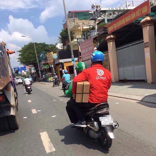 Thanh niên áo xanh GrabBike đèo bạn áo đỏ Go Việt, đội mũ Uber là hình ảnh ấm áp nhất MXH hôm nay