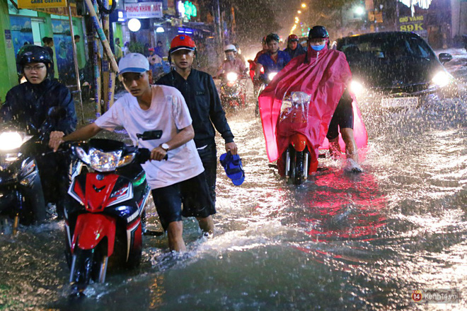 Học sinh, dân công sở khốn khổ vì nước ngập lút bánh xe trong cơn mưa kéo dài đến đêm ở Sài Gòn