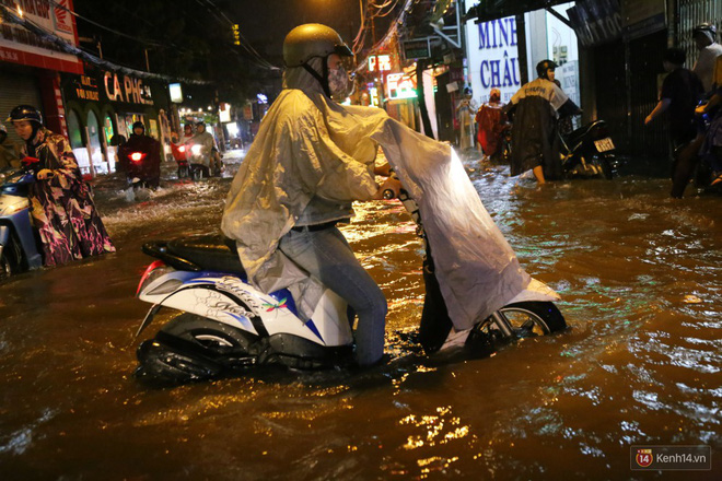 Học sinh, dân công sở khốn khổ vì nước ngập lút bánh xe trong cơn mưa kéo dài đến đêm ở Sài Gòn
