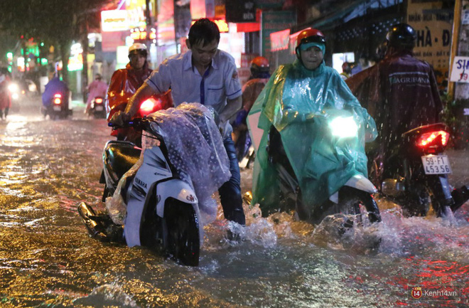Học sinh, dân công sở khốn khổ vì nước ngập lút bánh xe trong cơn mưa kéo dài đến đêm ở Sài Gòn
