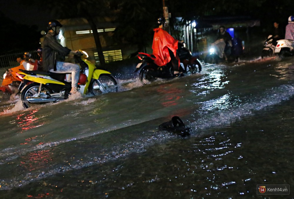 Học sinh, dân công sở khốn khổ vì nước ngập lút bánh xe trong cơn mưa kéo dài đến đêm ở Sài Gòn