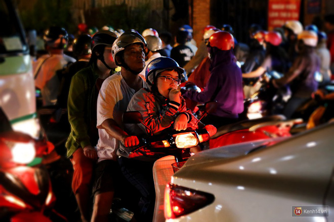 Kẹt xe kinh hoàng sau cơn mưa chiều ở Sài Gòn, trẻ em mệt mỏi ngủ trên xe máy