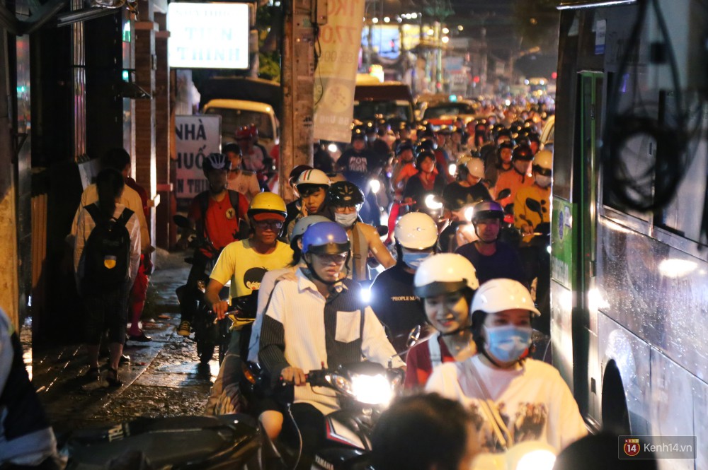 Kẹt xe kinh hoàng sau cơn mưa chiều ở Sài Gòn, trẻ em mệt mỏi ngủ trên xe máy