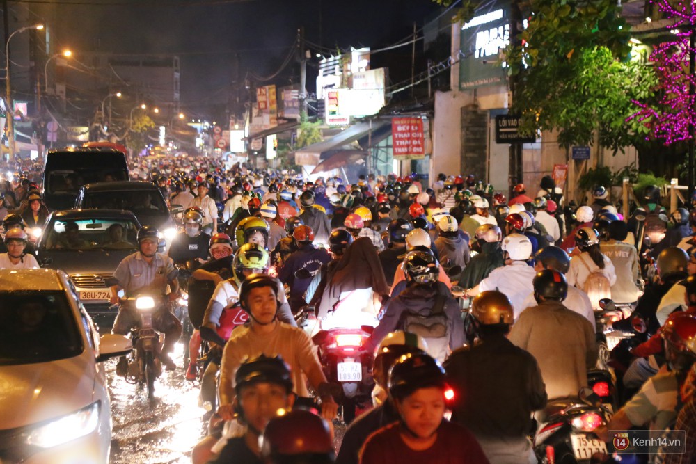 Kẹt xe kinh hoàng sau cơn mưa chiều ở Sài Gòn, trẻ em mệt mỏi ngủ trên xe máy