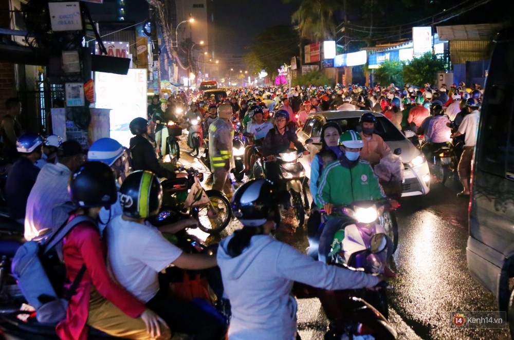 Kẹt xe kinh hoàng sau cơn mưa chiều ở Sài Gòn, trẻ em mệt mỏi ngủ trên xe máy