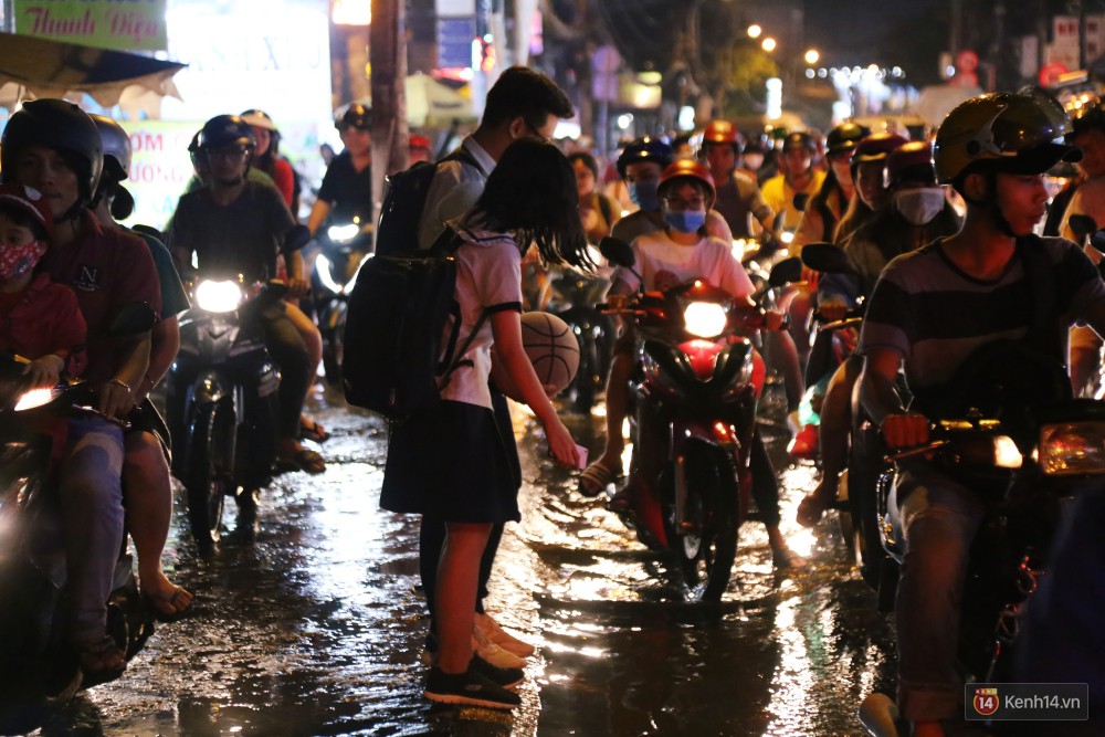 Kẹt xe kinh hoàng sau cơn mưa chiều ở Sài Gòn, trẻ em mệt mỏi ngủ trên xe máy