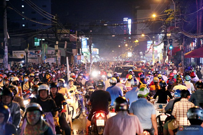 Kẹt xe kinh hoàng sau cơn mưa chiều ở Sài Gòn, trẻ em mệt mỏi ngủ trên xe máy