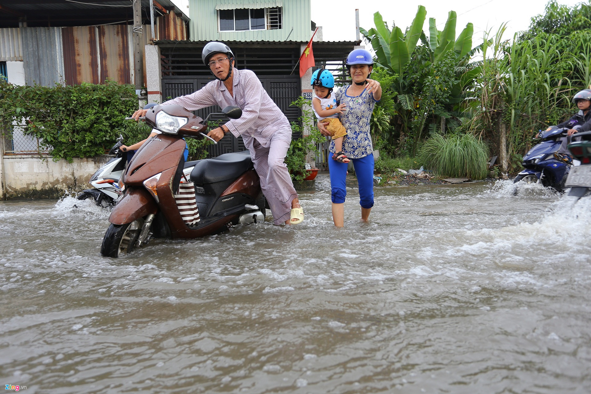 Triều cường Sài Gòn dâng cao, học sinh lội nước theo cha mẹ về nhà