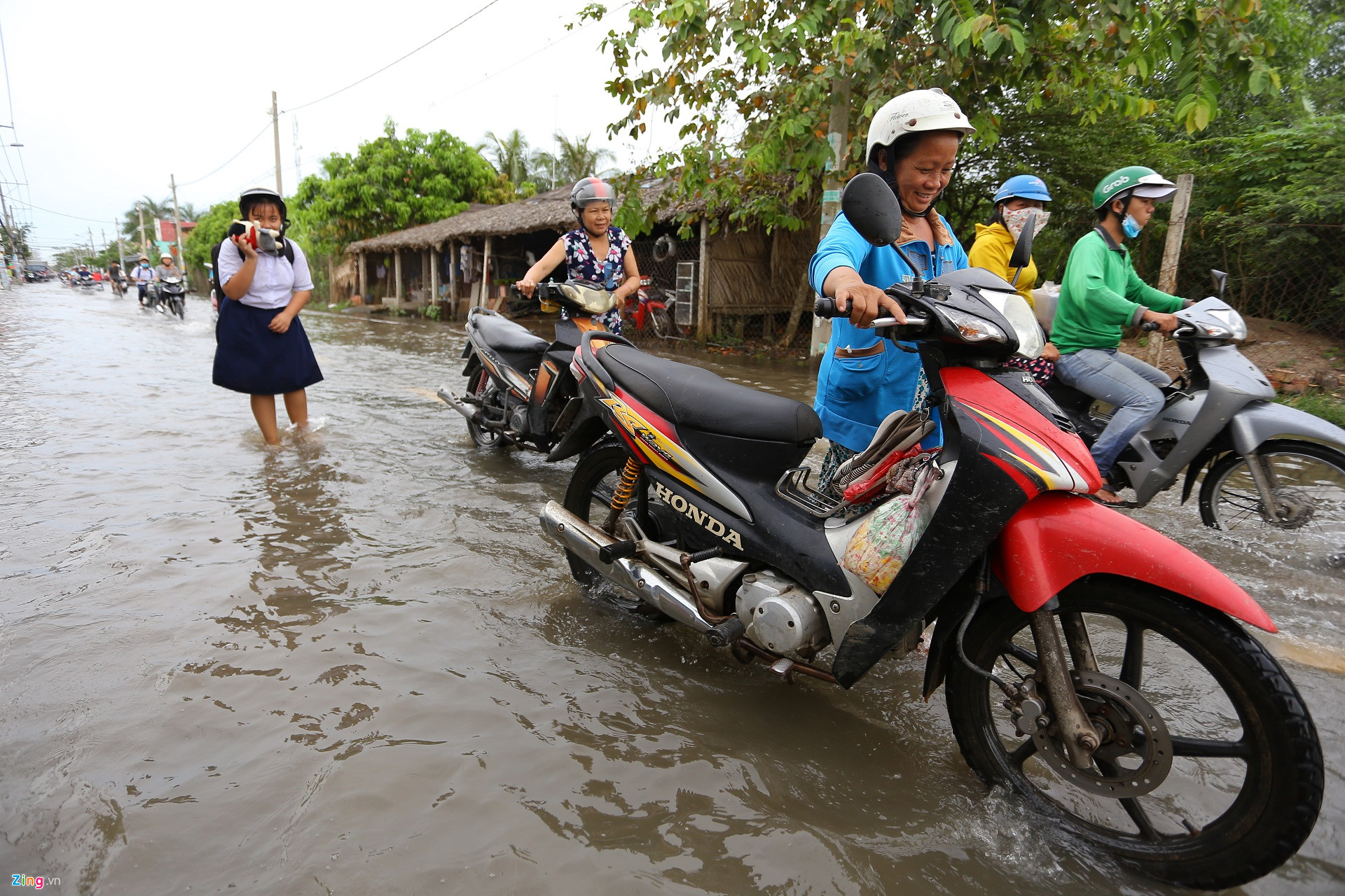 Triều cường Sài Gòn dâng cao, học sinh lội nước theo cha mẹ về nhà