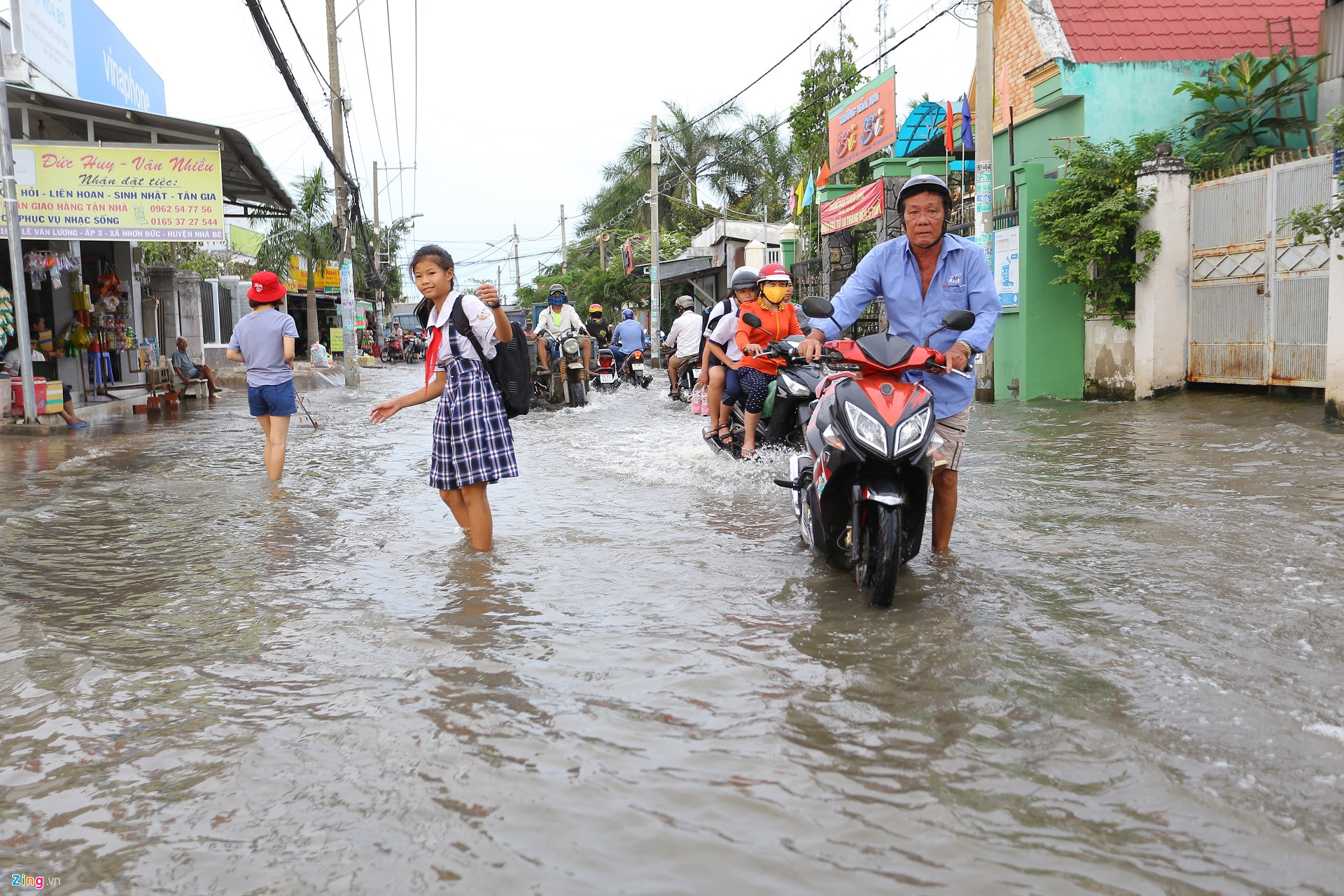 Triều cường Sài Gòn dâng cao, học sinh lội nước theo cha mẹ về nhà