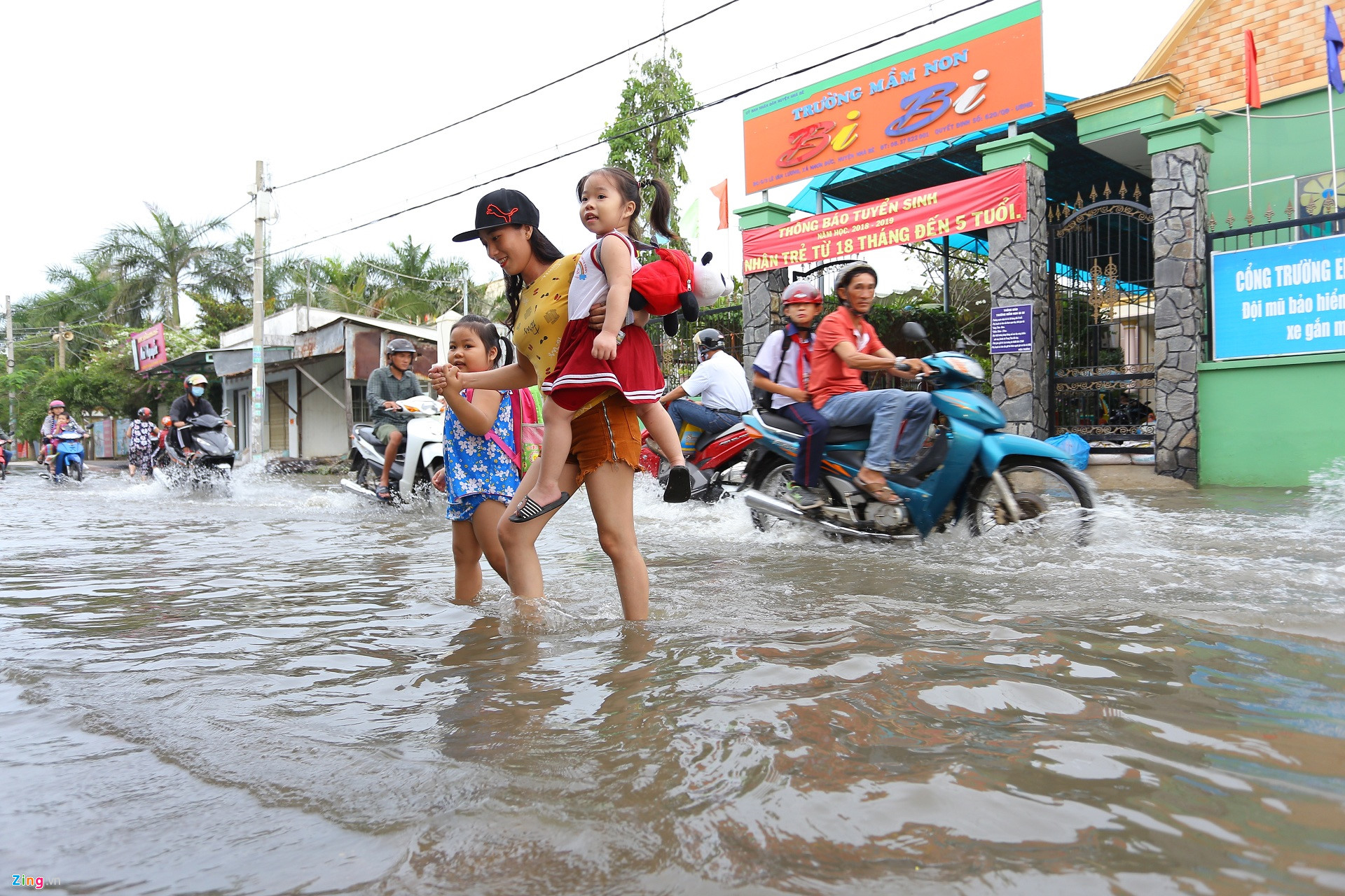 Triều cường Sài Gòn dâng cao, học sinh lội nước theo cha mẹ về nhà