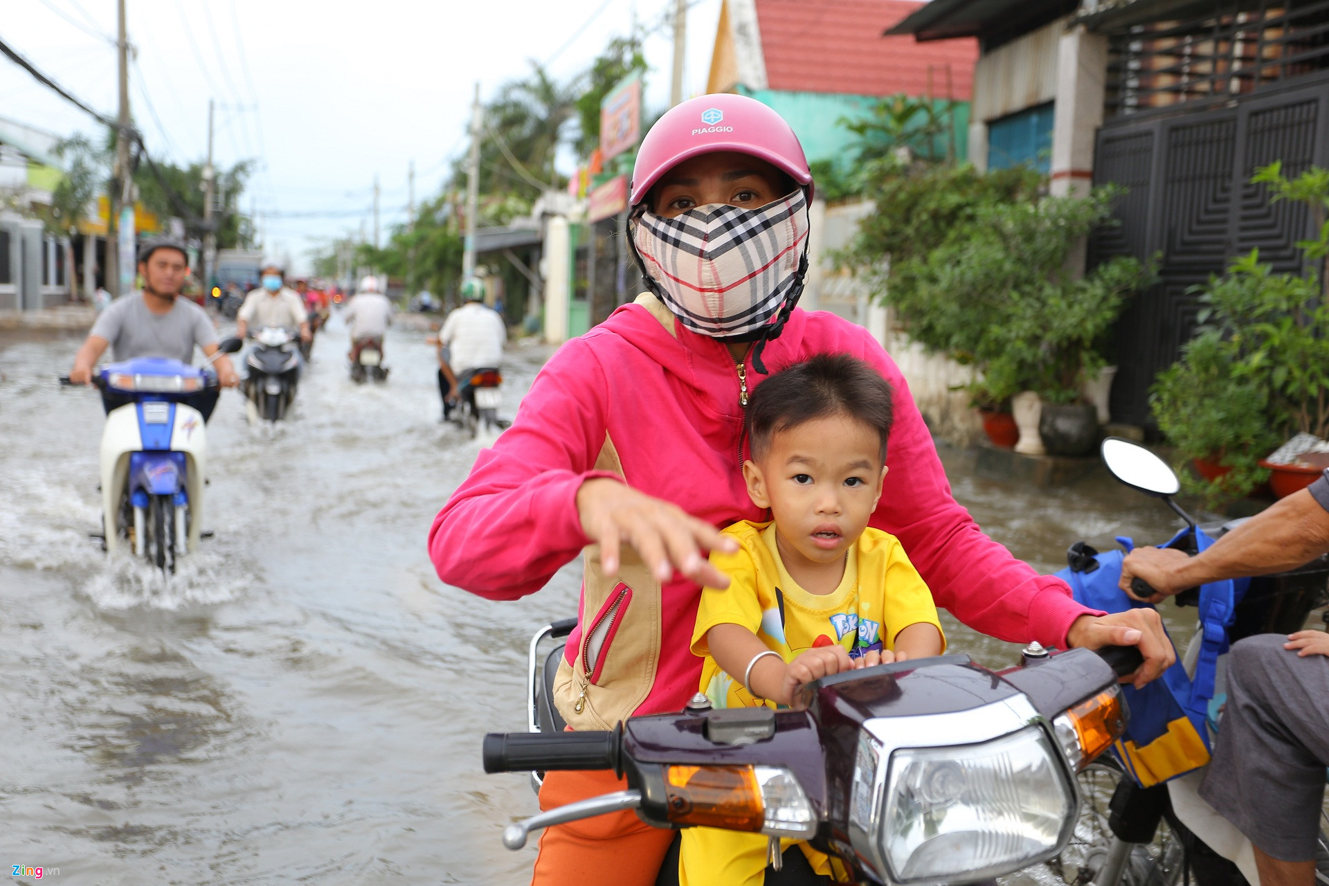 Triều cường Sài Gòn dâng cao, học sinh lội nước theo cha mẹ về nhà