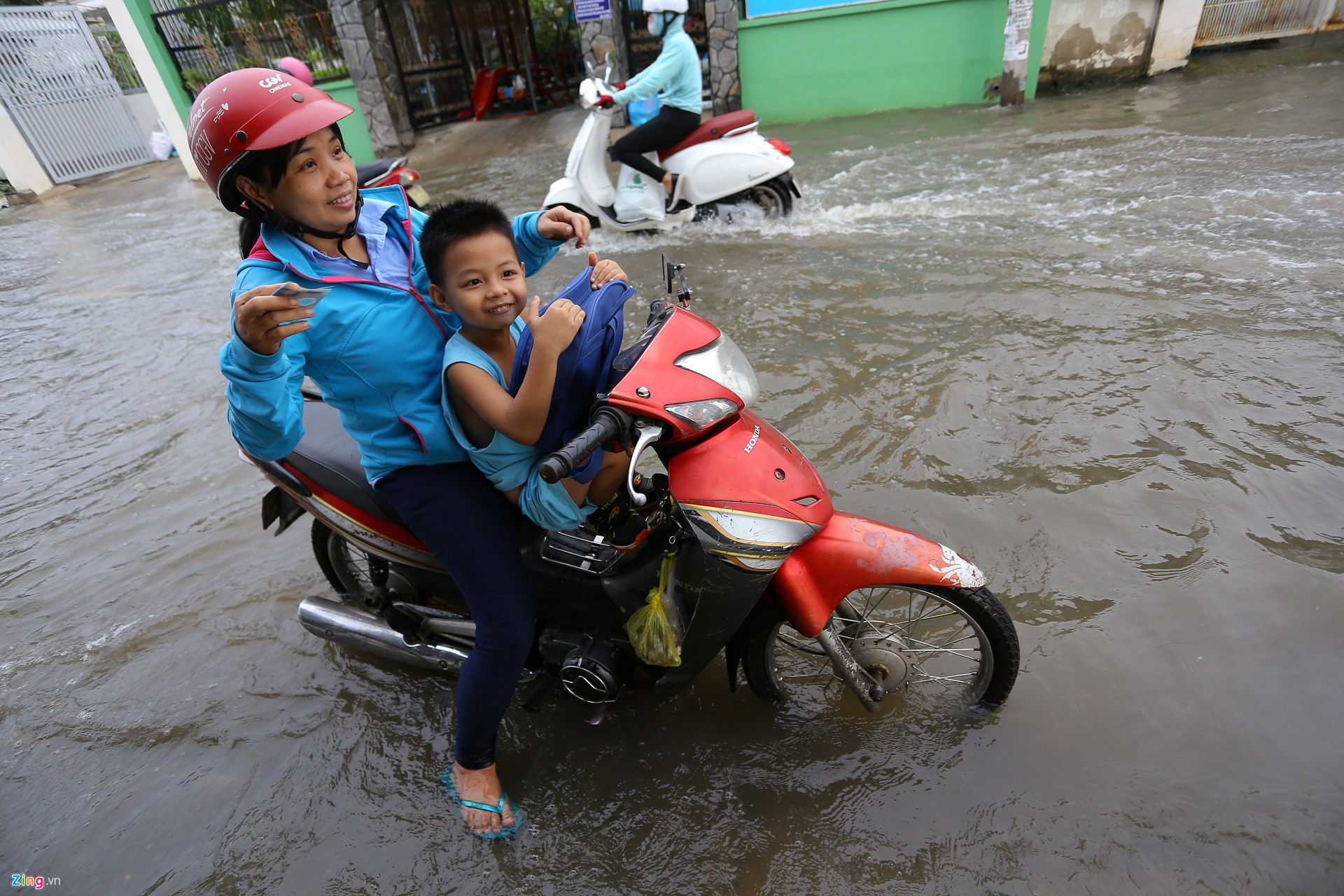 Triều cường Sài Gòn dâng cao, học sinh lội nước theo cha mẹ về nhà