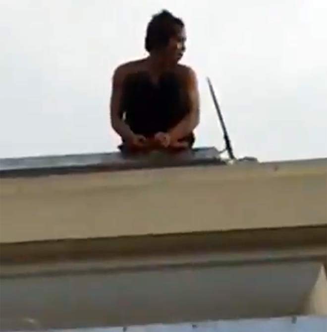 Thanh niên nghi ngáo đá leo lên nóc nhà kho bạc ngồi ngẩn ngơ