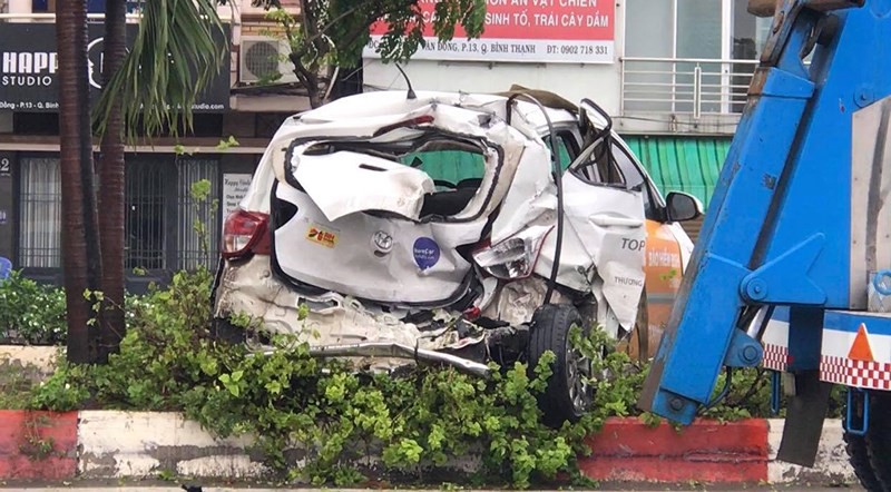 Xe tải húc văng ô tô lên dải phân cách đường Phạm Văn Đồng