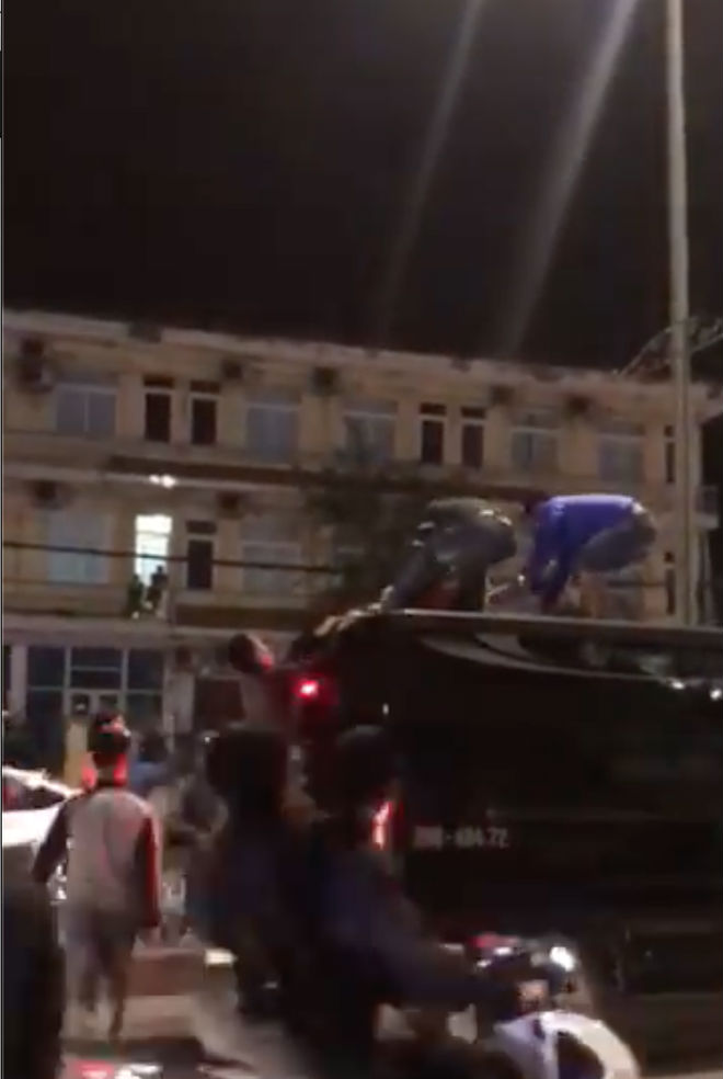 Clip sốc: Cô gái mặc váy đỏ trèo lên nóc ô tô nhảy múa, lăn lộn mặc người dân cố khuyên can