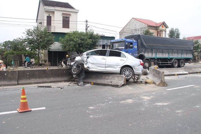 Xế hộp nằm gọn trên dải phân cách sau cú va chạm với xe container