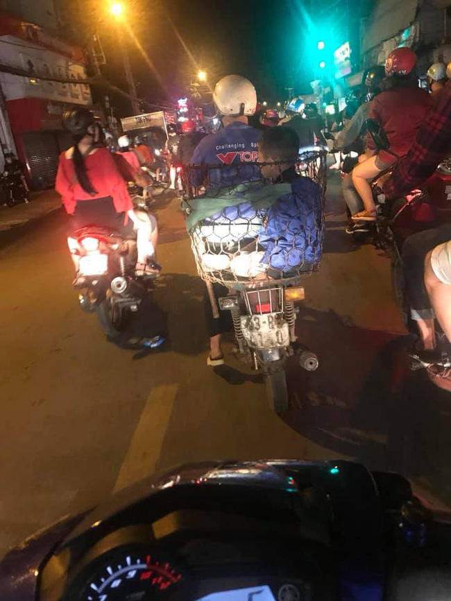 Bức ảnh cha chở 2 con đi đón năm mới trong chiếc sọt thồ hàng khiến nhiều người cảm động