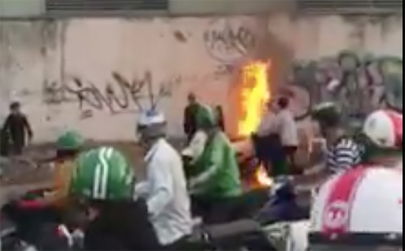 Hai vợ chồng trẻ bất lực đứng nhìn xe tay ga bốc cháy trên đại lộ Phạm Văn Đồng