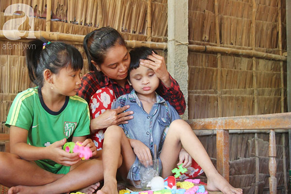 Bố bị chấn thương sọ não, con trai mù 6 tuổi gục đầu lên vai mẹ, ú ớ lấy lá dừa hốt cát để ăn