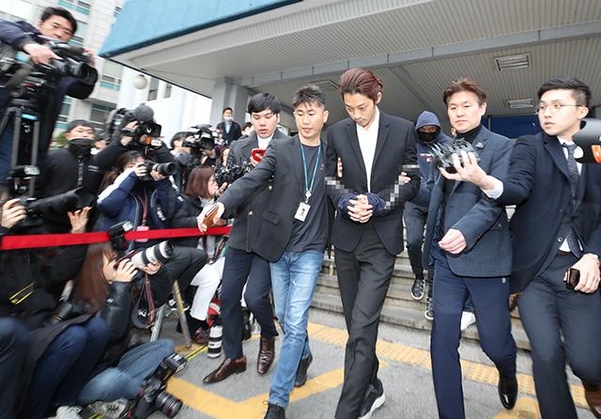 Jung Joon Young bị trói bằng dây thừng, còng tay áp giải sang phòng công tố