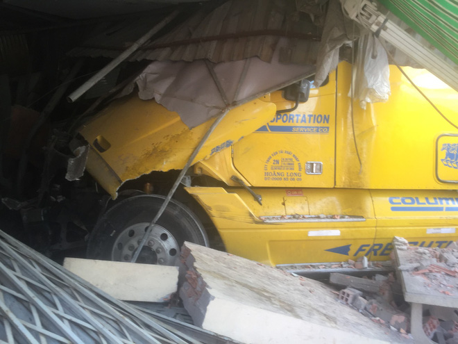 Tài xế xe container vẫn say sưa ngủ trong cabin sau khi tông sập 2 nhà dân ở Sài Gòn