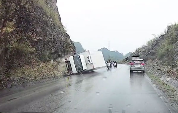 Clip: Xe tải ôm cua mất lái đâm vào sườn núi rồi lật ngang, hàng loạt xe máy may mắn thoát tai nạn trong gang tấc