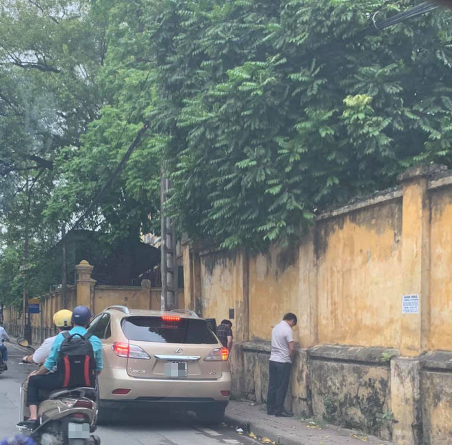 Hình ảnh 2 quý ông đứng tiểu bậy ngay cạnh xe Lexus đậu bên đường Hà Nội khiến nhiều người bức xúc
