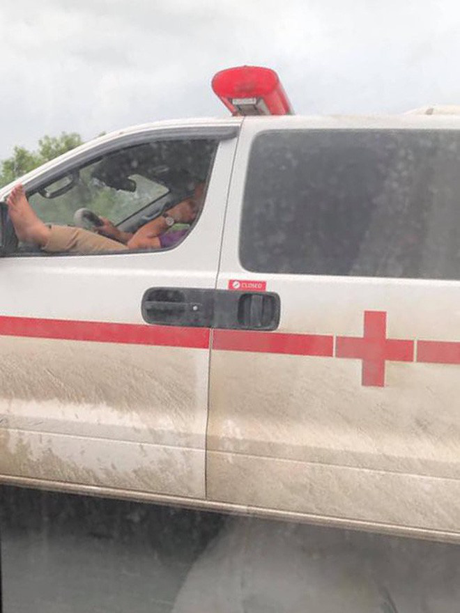 Thót tim cảnh tài xế xe cứu thương vừa lái xe băng băng trên cao tốc vừa gác chân lên cửa sổ và nghe điện thoại