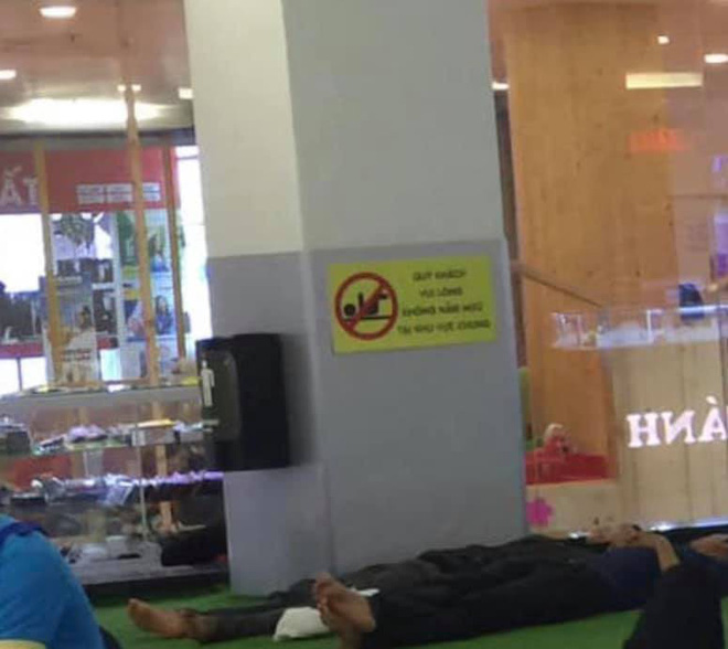 Hình ảnh người dân nằm dài tránh nóng trong TTTM bất chấp biển cấm ngay bên cạnh khiến nhiều người nhíu mày