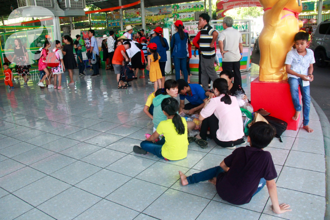 Càng về trưa càng nóng bức, nhiều gia đình nhanh chân tìm tới các bóng râm, nơi thoáng mát để tránh nắng.