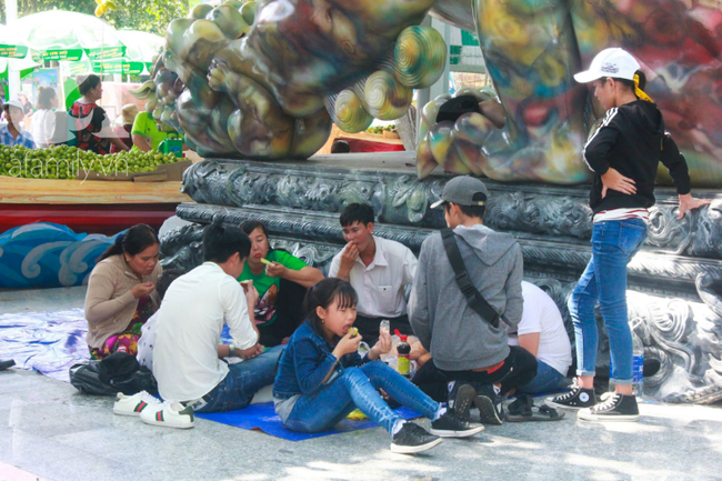 Đến tầm trưa, nhiều gia đình mang theo thức ăn, nước uống tới những nơi trống người, có bóng râm để tranh thủ ăn trưa sau một buổi sáng vui chơi.