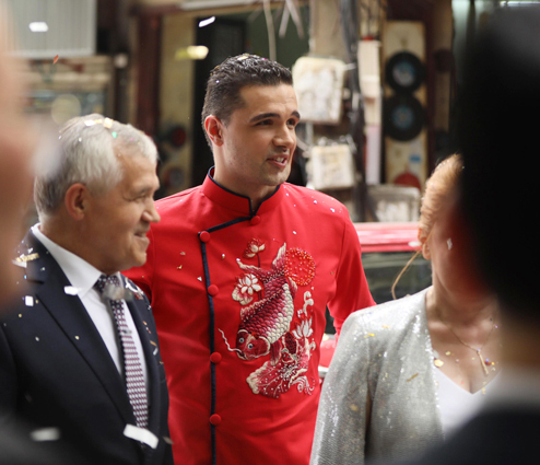 Chú rể Marcin diện áo dài đỏ in hình cá chép