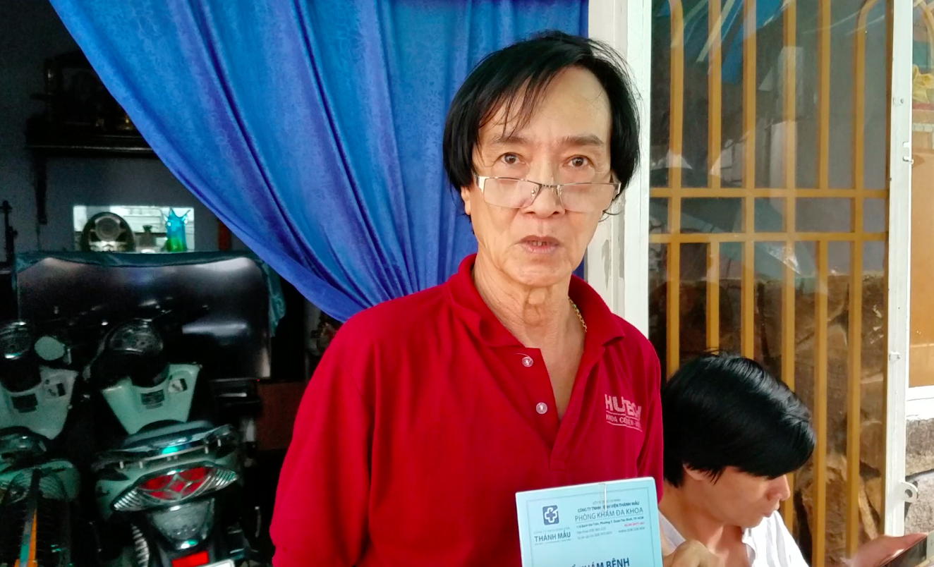 Ông Đức cầm sổ khám bệnh sau khi vừa xuất viện về nhà vì bị ngộ độc.