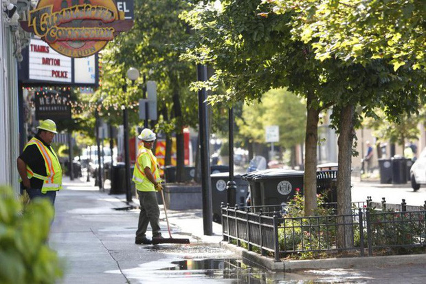 Các nhân viên đang dọn vỉa hè hiện trường sau vụ xả súng hôm 4-8. Ảnh: EPA-EFE