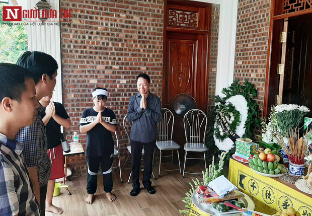 Anh Lê Văn Sơn, bố cháu L. (ngoài cùng bên phải) khóc nghẹn bên di ảnh của con.