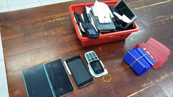 Tang vật thu giữ gồm nhiều điện thoại và thẻ nhựa để còn bạc đặt cược. (Ảnh: PLO)