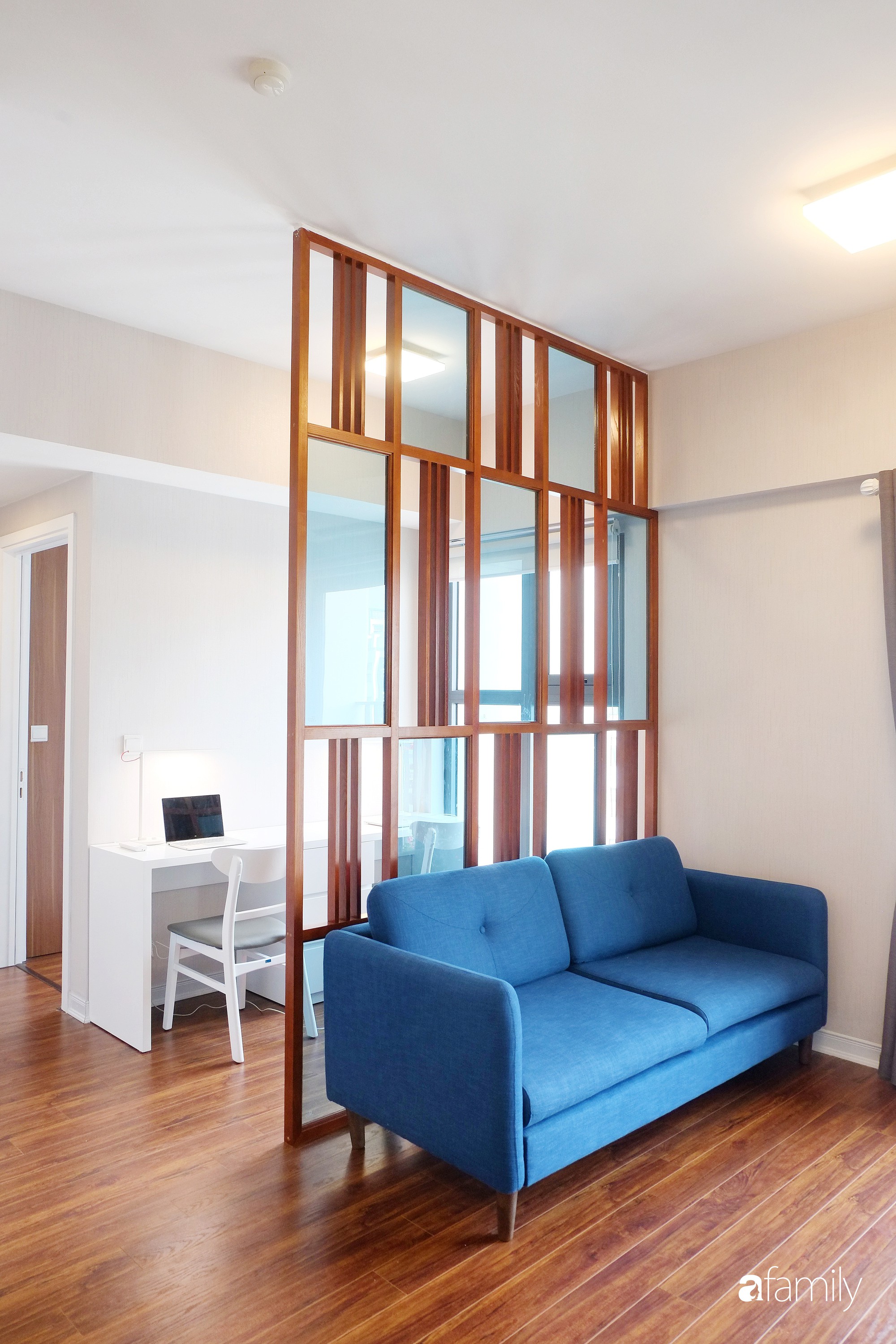 Vách ngăn gỗ được decor đặc biệt để ngăn cách khu vực phòng khách với nơi làm việc.