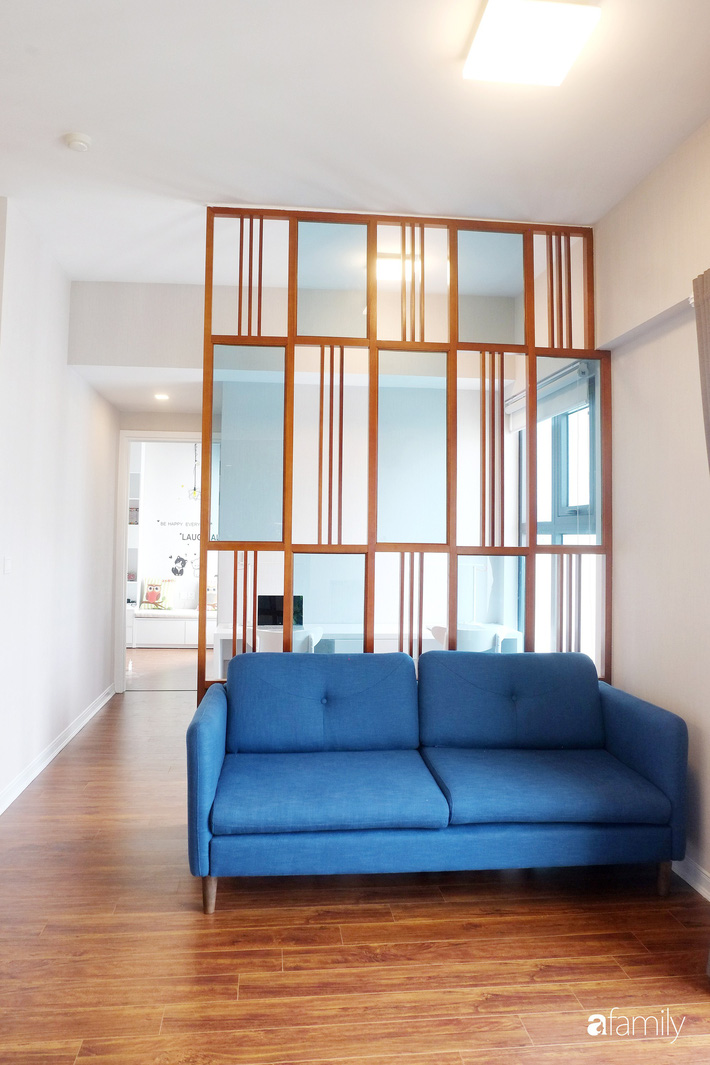 Phòng khách được thiết kế đơn giản với sofa màu xanh biển làm màu nhấn vui mắt, sinh động. Phía trước là kệ tivi gắn tường phù hợp cho thói quen, nhu cầu sinh hoạt hàng ngày của gia đình.