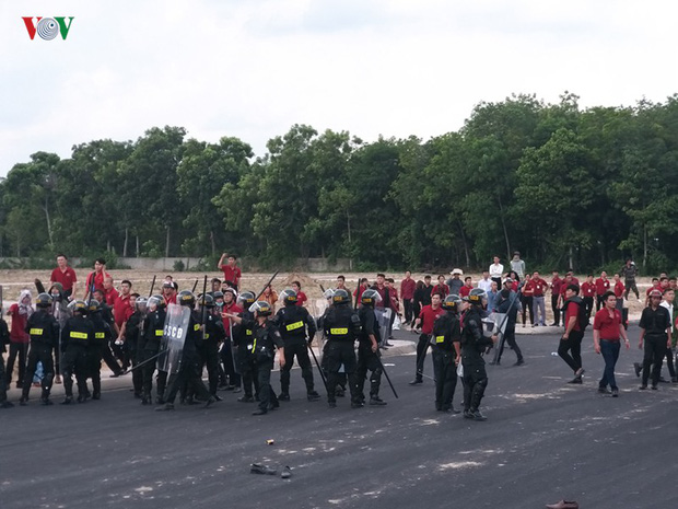 Nhóm người mặc áo đỏ có dòng chữ Địa ốc Alibaba chống đối đoàn cưỡng chế.