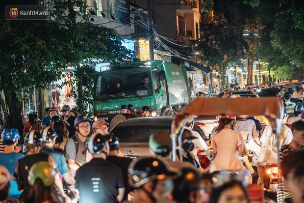 Xe rác cố gắng di chuyển giữa biển người tại ngã tư Hàng Mã - Phùng Hưng.