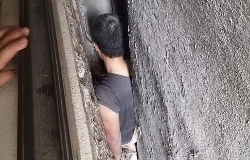 Người đàn ông mắc kẹt ở khe hở giữa 3 ngôi nhà