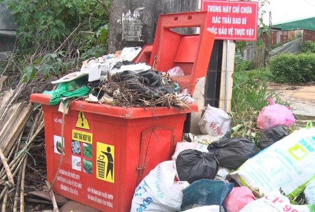 Rác đầy ứ bên trong và chất đống bên ngoài thùng